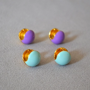 Macro shot of colorful enamel glazed brass gold-plated hoop earrings in blue and purple