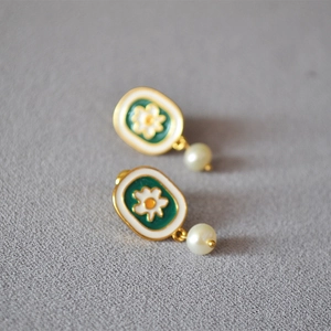 Detail of vintage oval green enamel earrings with white flower and freshwater pearl drop