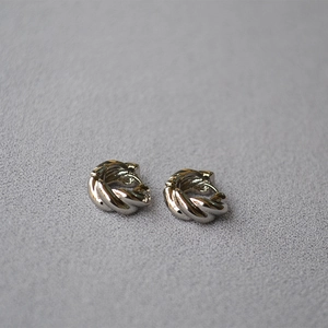 Close-up of silver twist croissant earrings with a high-polished mirror finish
