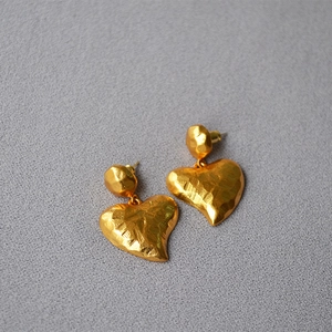 Detail of vintage hammered texture gold-plated heart earrings with 925 silver pins