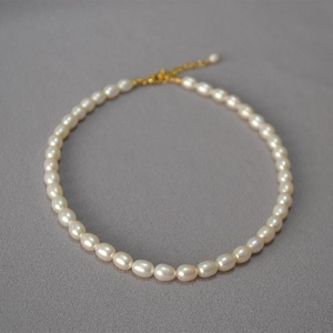 Dettaglio di collana di perle d'acqua dolce con chiusura a moschettone dorata regolabile