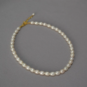 Dettaglio collana di perle d'acqua dolce con chiusura dorata regolabile e catena estensibile
