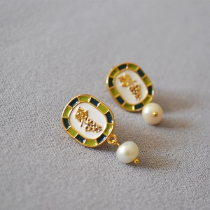Close-up of vintage grape earrings with enamel details and hanging white pearls