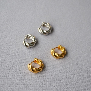 Detailed view of twisted croissant hoop earrings in gold and silver plated finish