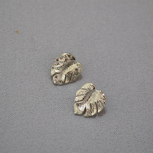 Silver palm leaf stud earrings with sparkling cubic zirconia and matte hammered finish