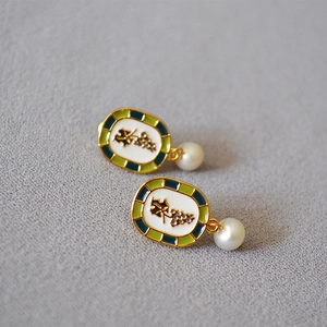 Detail of handmade enamel grape earrings with pearls and gold-plated brass frames