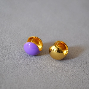 Detailed close-up of gold-plated brass hoops with purple enamel drip finish