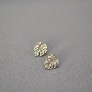 Detailed close-up of sparkling silver monstera leaf earrings with textured zircon inlay