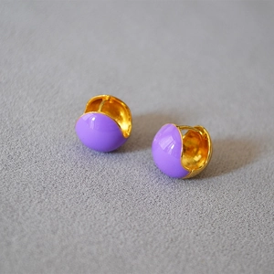 Detailed close-up of purple enamel hoop earrings with polished brass gold plating