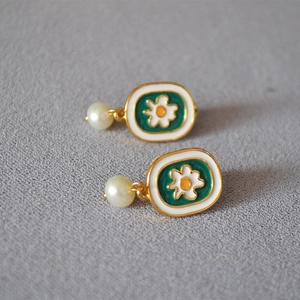 Detailed view of handmade enamel daisy earrings with elegant freshwater pearls
