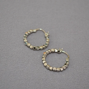 Détail de boucles d'oreilles créoles perlées avec billes carrées polies argent
