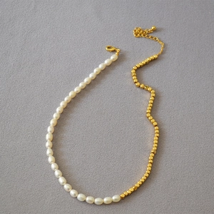 Detail of freshwater pearl necklace with faceted golden beads and lobster clasp
