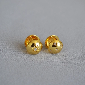 Close-up of gold-plated North Star earrings with sparkling cubic zirconia inlay