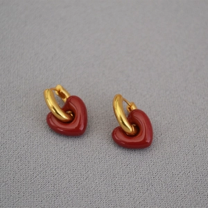 Detailed view of vintage gold hoop earrings featuring bold red enamel heart pendants