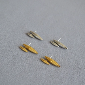 Détails de boucles d'oreilles dorées et argentées au design épuré et minimaliste de rivets