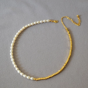 Detail of freshwater pearl and golden square bead necklace with lobster clasp