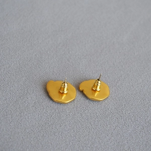 Back view of gold enamel star and moon stud earrings showing needle and butterfly closure
