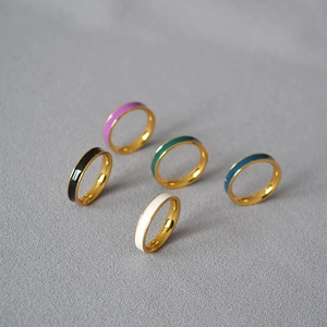 Detail of five colorful enamel minimalist gold-plated rings in a variety of vibrant shades