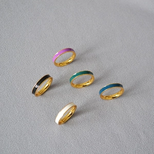 Detailed top view of five-piece minimalist gold-plated brass rings with colorful enamel
