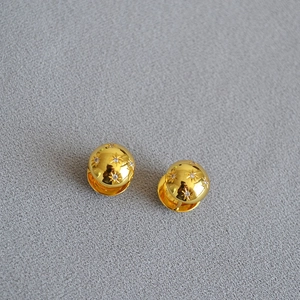 Macro detail of gold plated North Star earrings with embedded sparkling zircons
