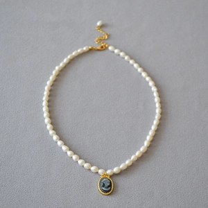 Detail of freshwater rice pearl necklace with a vintage black cameo relief pendant