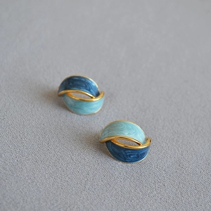 Dettaglio di orecchini vintage in ottone con perni in argento 925 e smalto bluastro