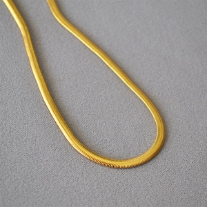 Flat gold snake chain necklace in minimalist brass for a retro fashion statement
