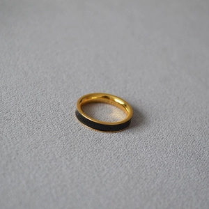 Detail of minimalist gold plated brass ring featuring sleek black enamel inlay textures