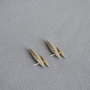 Boucles d'oreilles rivets argentées minimalistes au design conique sur fond sombre