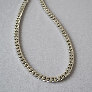 Detailed view of heavy punk Cuban link chain with polished stainless steel surface