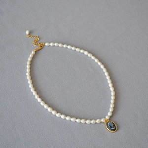Detail of freshwater rice pearl necklace with a vintage cameo relief pendant and gold clasp