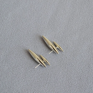 Détail de boucles d'oreilles argentées modernes au design profilé à deux pointes fines