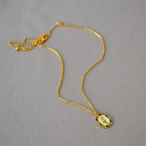 Detailed shot of vintage gold necklace with white grape enamel pendant and lobster clasp