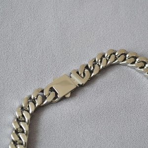 Macro shot of industrial buckle clasp on silver stainless steel heavy Cuban chain