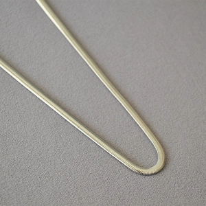Minimalist wide flat snake bone chain necklace in gold plated brass with polished finish