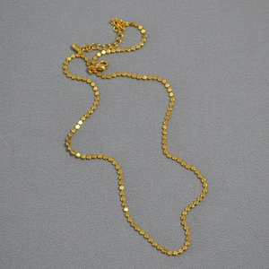 Detailed macro view of minimalist gold plated disc choker with lobster clasp closure