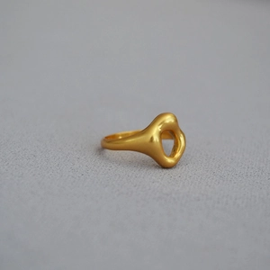 Irregular organic hollow ring in matte gold plated brass with a minimalist artistic style