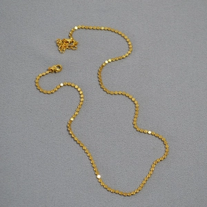 Detailed view of the flat gold disc chain necklace with secure lobster claw clasp
