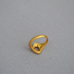 Macro view of textured gold-plated irregular ring showing organic geometric shape