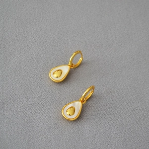 Macro view of pear-shaped brass earrings with gold plating and inlaid mother of pearl