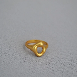 Macro view of a gold-plated irregular ring with organic cut-out and matte texture