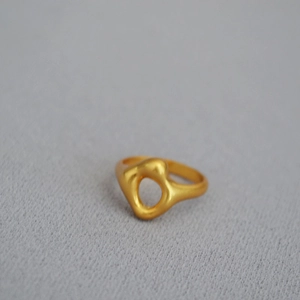 Detail shot of irregular hollow geometric gold-plated brass ring with matte finish