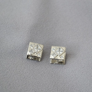 Macro shot of silver plated square earrings featuring geometric cubic zirconia stones