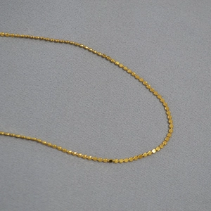 Minimalist gold-plated brass choker featuring a delicate shiny disc scale texture design