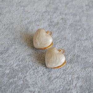 Detailed shot of gold-plated brass heart earrings with white marble resin texture