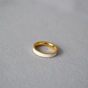 Detailed close-up of a slim 18K gold-plated brass ring with white enamel inlay