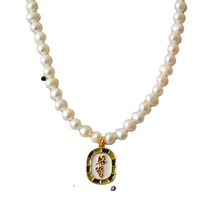 Vintage necklace with natural pearls and golden enamel grape pendant on white background