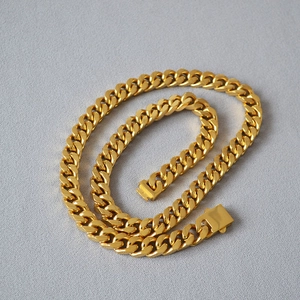 Polished heavy gold Cuban link chain necklace with square clasp in a minimalist layout