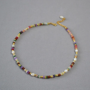 Dettaglio di perle in pietra colorata e perle d'acqua dolce su collana placcata in oro