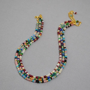 Detail of colorful beaded Bohemian necklace with golden clasp and extender chain